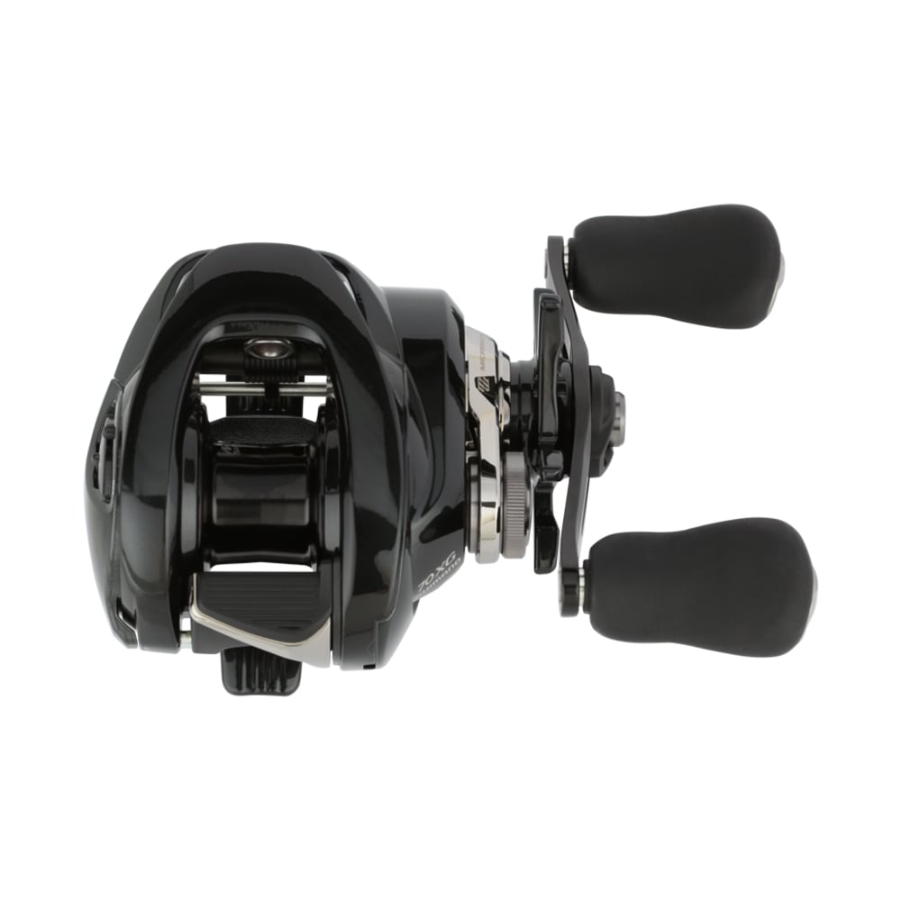 A black and silver baitcasting fishing reel with two grip handles, viewed from the side. It has a sleek design with reflective surfaces, showing detailed mechanical components.