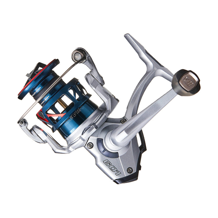 Close-up of a modern fishing reel with a metallic silver body and blue accents. The reel features a sleek design, visible gears, and a crank handle on the right side.