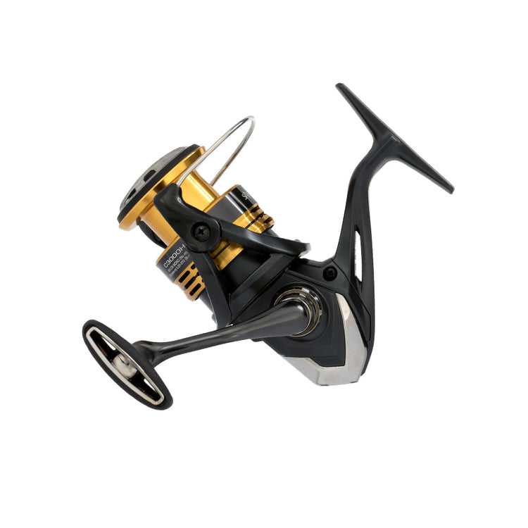 Fishing reel with a sleek black and gold design, featuring a prominent handle and spool, isolated on a white background.