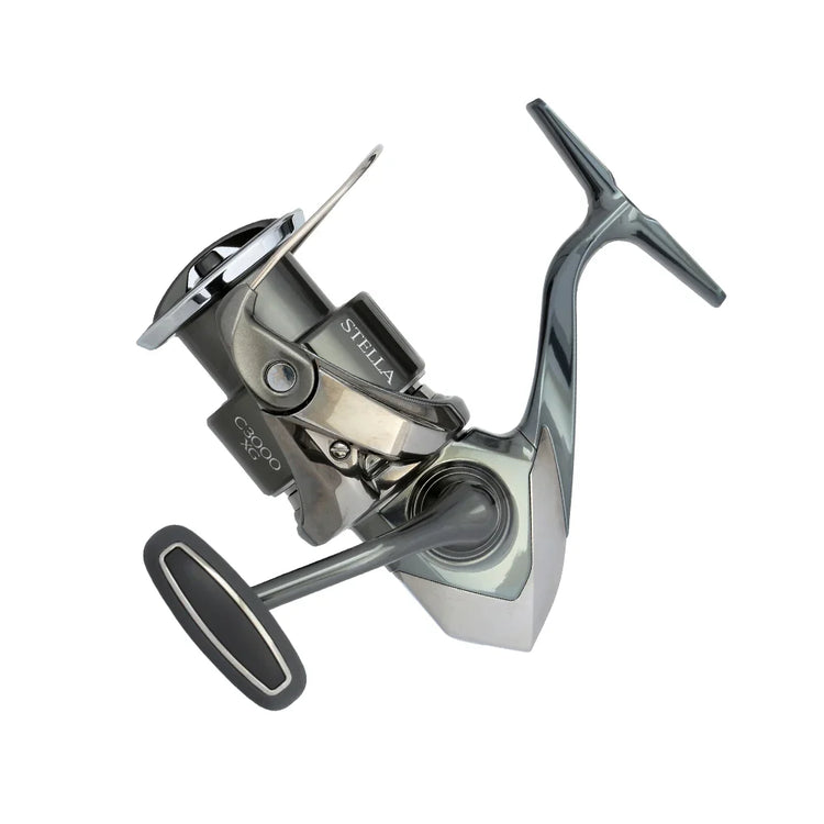 Fishing reel with a sleek, metallic design, featuring a prominent handle and visible spooling mechanism. The brand name "Stella" is printed on the side. The background is plain white.