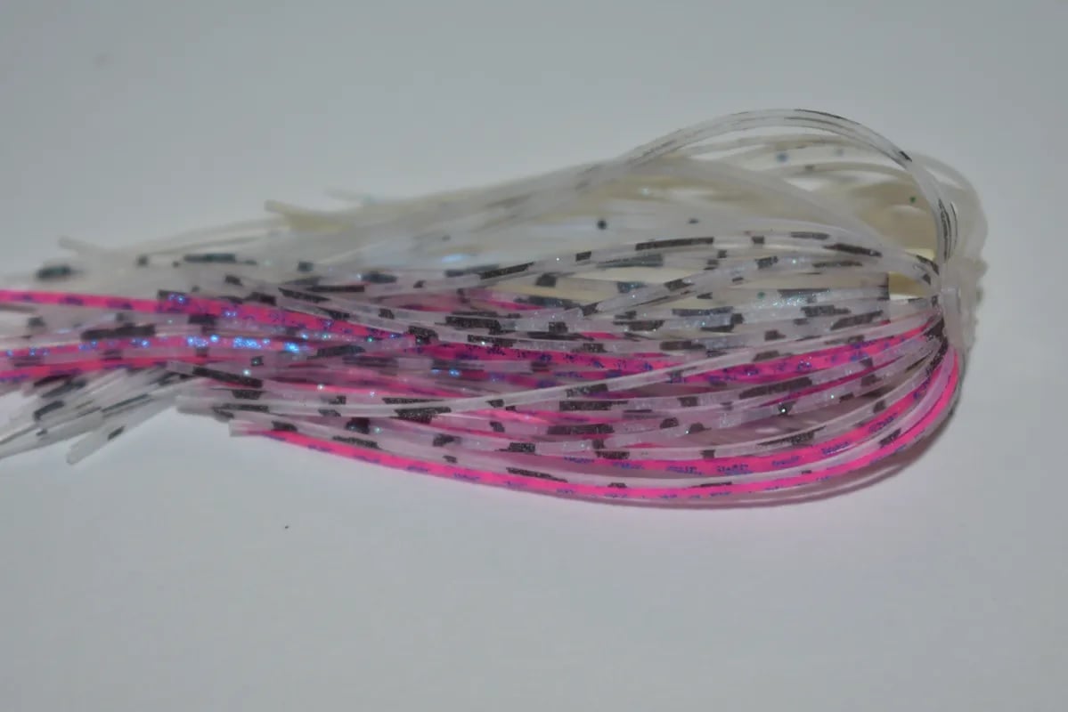 A close-up shows colorful silicone strands for Accent's River Special Spinnerbaits. Predominantly white, pink, and gray with reflective glitter accents, the strands are neatly displayed against a plain white background.