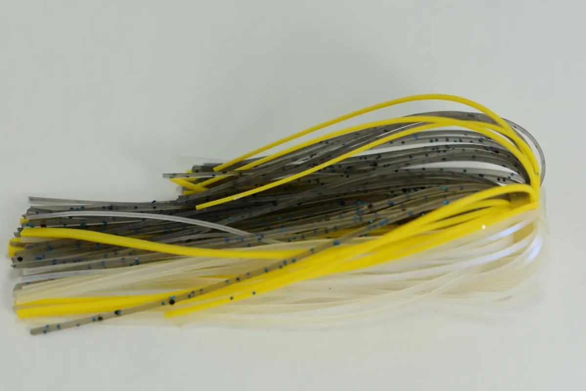 The Accent River Special Spinnerbaits by Accent features flexible strands in colors such as yellow, gray, and white with black spots, fanned out against a white background.