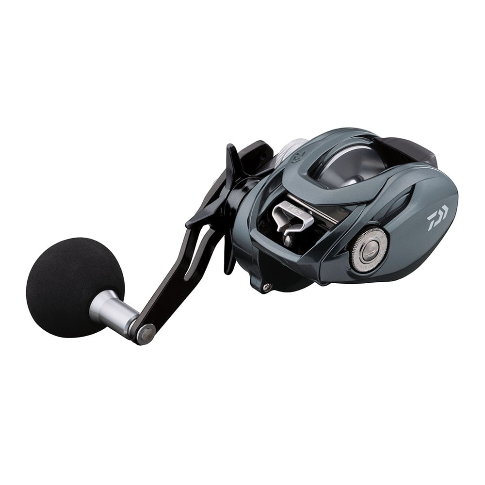 An angled close-up of the Daiwa's Lexa TW Casting Reel 300-P 6.3:1 (LX-TW300-P) showcases its sleek metallic gray body, black round foam-covered handle, and innovative T-Wing System, highlighting its intricate design and components.