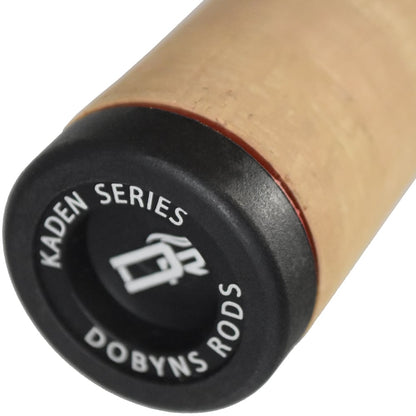 Close-up of the handle on the Dobyns Kaden Casting Rods 7'4" Heavy | KD 744C, showcasing a full cork grip and a black end cap featuring "Kaden Series," "Dobyns Rods," and their logo, representing high modulus blanks craftsmanship.