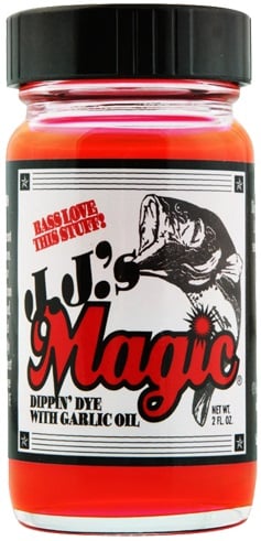 This 2 fl. oz. jar of JJ's Magic Dippin' Dye with Garlic Oil is a strong fish attractant featuring a red liquid, ideal for enhancing soft plastic baits. Its label showcases a fish and the bold phrase "Magic," accompanied by "Bass Love This Stuff?.