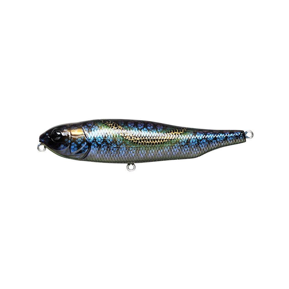 The Megabass Giant Dog-X is a realistic, shiny fishing lure resembling a fish with iridescent blue, green, and gold scales. It features a silver underside, metal loops for hooks on the head and tail, and offers roll-walking action due to its lateral tungsten balancer.