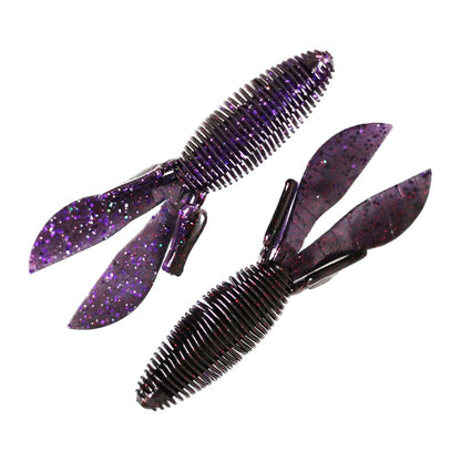 Two Missile Baits D Bomb lures from Missile Baits shimmer enticingly in dark purple with glitter. Designed as creature baits, these ribbed plastic fishing lures feature two flat, paddle-like tails and are perfect for pitching and flipping techniques. They are artfully positioned side by side on a white background.