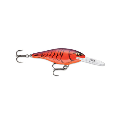 The Rapala Shad Rap Crankbait by Rapala features a vibrant orange and red body with dark scale patterns, dual treble hooks, and a clear plastic lip, making it ideal for diving underwater and mimicking baitfish movement.