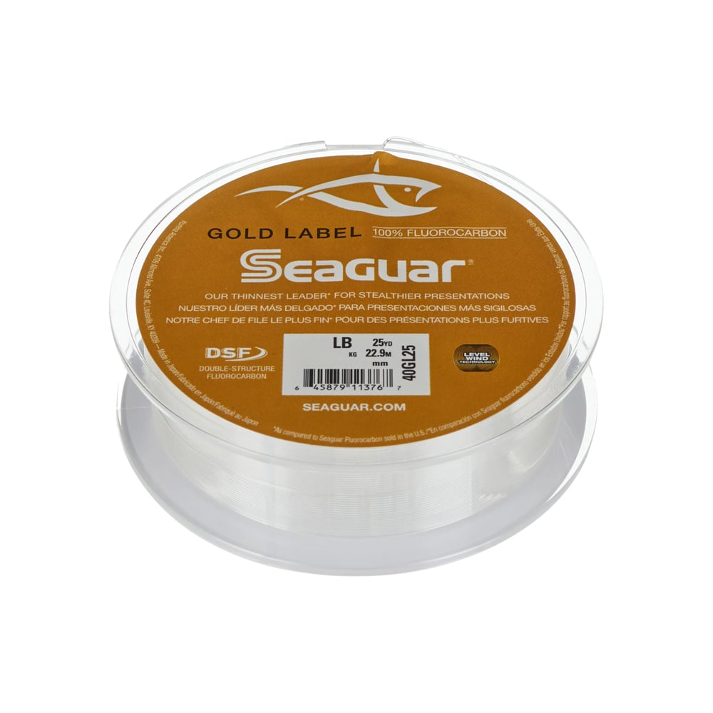 A spool of Seaguar Gold Label Fluorocarbon Leader 25yd, perfect for clear water walleyes, displays the Seaguar brand logo on a brown and gold label indicating a 25-pound weight capacity. The transparent spool showcases the durable fishing line inside.