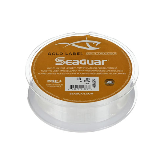 A spool of Seaguar's Gold Label Fluorocarbon Leader 25yd, featuring trilingual labeling in English, Spanish, and French, is perfect for catching walleyes in clear water. The product is displayed against a clean white backdrop.