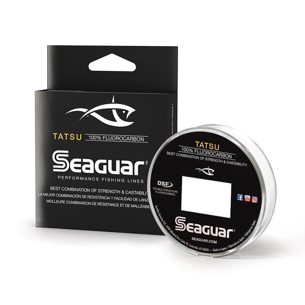 The image displays a box of Seaguar Tatsu Fluorocarbon Line, known for its dual-layer construction. The elegant black packaging features white lettering and the distinctive Seaguar logo. Next to it, a spool is visible, complete with detailed specifications for avid anglers.