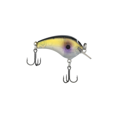 A detailed image of the Shimano Macbeth Tiny Crankbait fishing lure showcases a curved, fish-like body. It features a yellow and gray gradient with black spots and two sharp treble hooks at the bottom. A clear lip extends from the front for precision diving action, merging finesse with innovation.