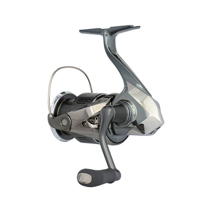 A close-up of the Shimano Stella FK Spinning Reel 1000FK by americanlegacyfishing showcases its modern, geometric design. This high-tech reel features MicroModule II technology and a sleek handle, spool, and bail arm in gray and silver tones that enhance its polished look.