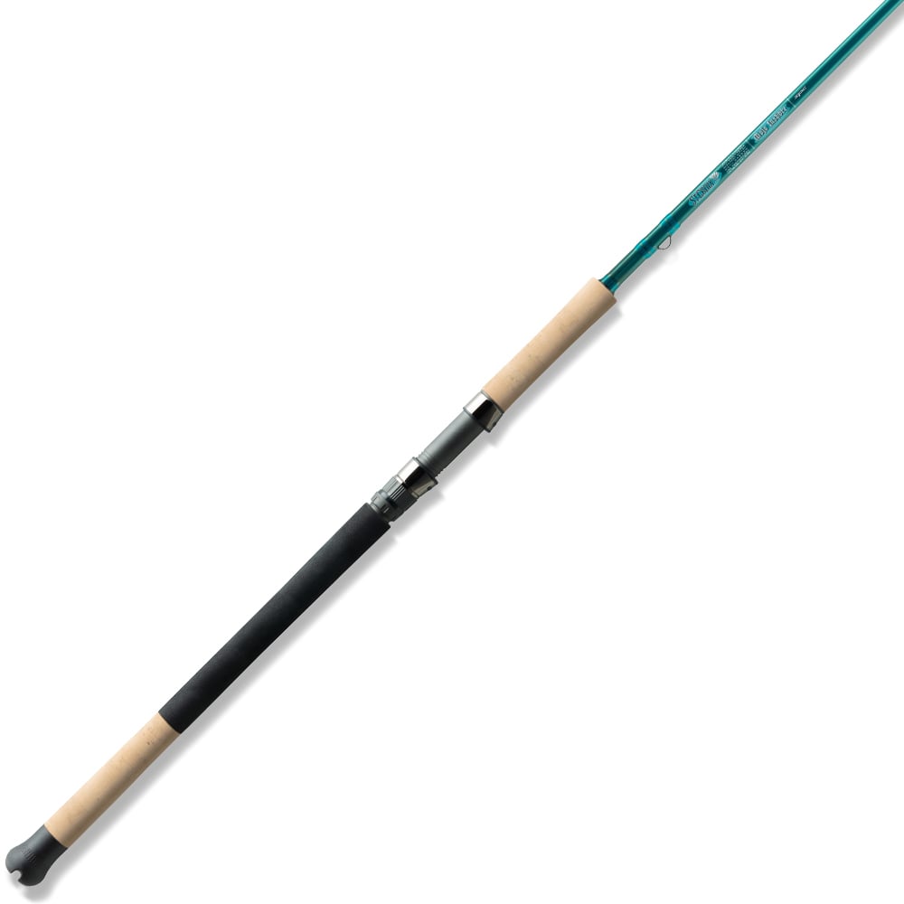 A sleek St. Croix Mojo Inshore Spinning Rod 7'11" Heavy Moderate Fast by americanlegacyfishing showcases a green body with a cork handle and black grip segments, featuring a metal reel seat. This versatile rod elegantly crosses the image background, making it perfect for saltwater adventures.