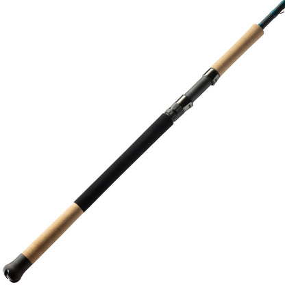 The St. Croix Mojo Inshore Spinning Rod 7'11" Heavy Moderate Fast (JIS711HMF) by American Legacy Fishing showcases a long, slender black design with cork handles on each end, set diagonally against a white background. It's meticulously crafted for saltwater fishing, featuring a perfectly positioned reel seat between the handles.