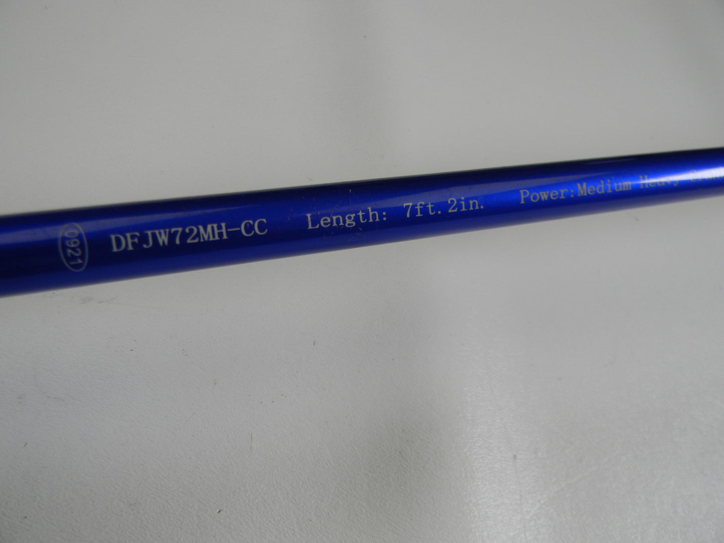 Close-up of a blue Duckett Wheeler Series rod with "DFJW72MH-CC," "Length: 7'2"," and "Power: Medium Heavy" text on a light gray background—ideal for our Rod and Reel Trade-In Program to assess your used gear condition for store credit.