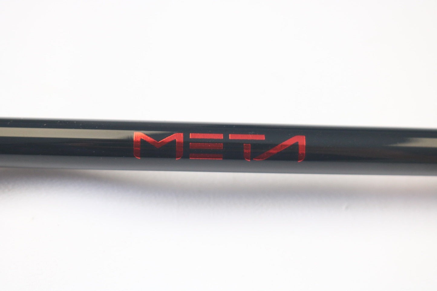 A close-up of a black 13 Fishing Meta MTGC74MH 7'4" Medium Heavy used casting rod with "META" in red, centered on a white background. Ideal for our Rod and Reel Trade-In program or for obtaining store credit on pre-owned gear.