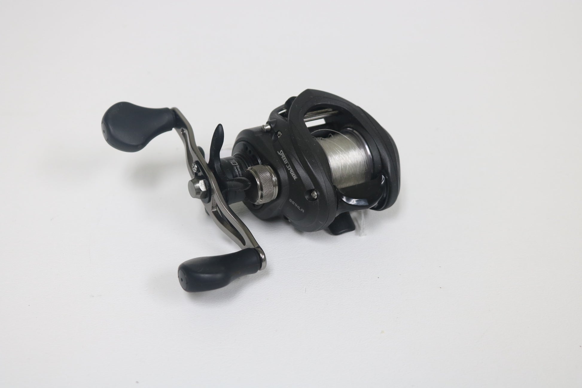 The Lew's Speed Spool SS1HLA 6:8:1 LH, a black baitcasting reel in very good used condition, features a silver spool and two-handled crank against a white background. Take advantage of our Rod and Reel Trade-In Program to earn store credit for your next upgrade!.