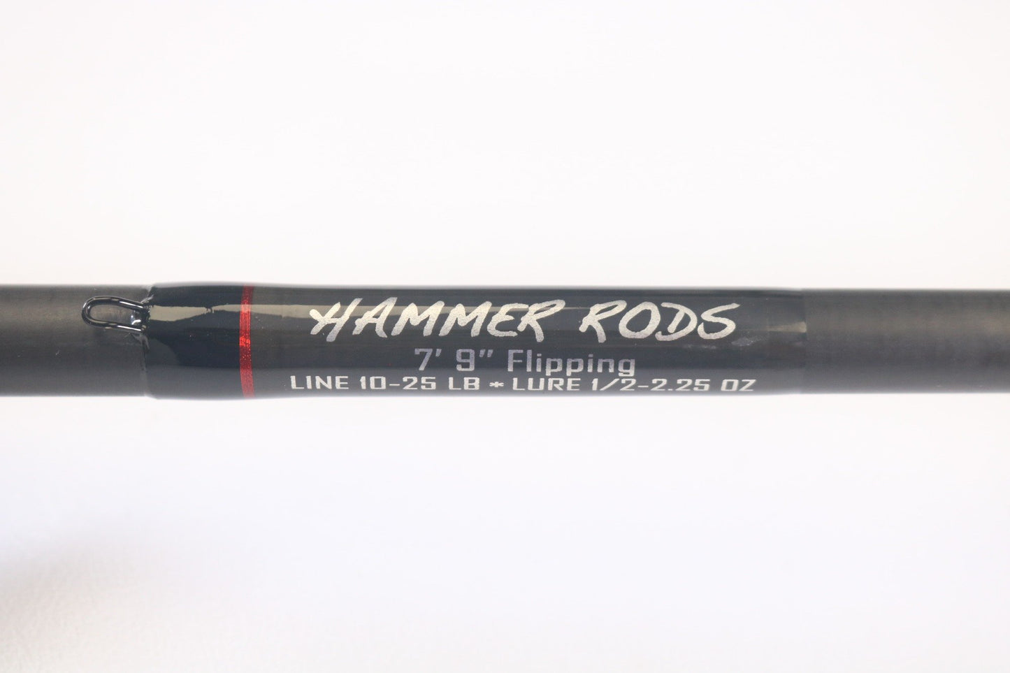 Close-up of a 7'9" Hammer Rods Micro Guide Flipping rod labeled "HAMMER RODS" on the handle, in our Rod and Reel Trade-In Program. Ideal for 10-25 lb line and 1/2-2.25 oz lures, this used casting rod is black with red accents, perfect for quality-seeking anglers.