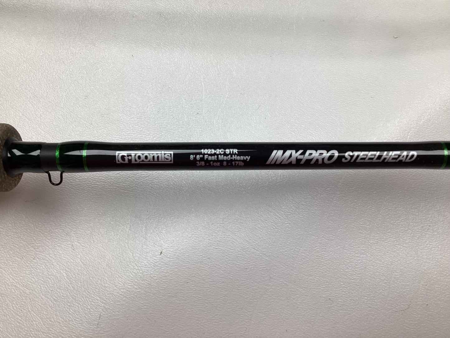 Close-up of a used G. Loomis IMX-PRO Steelhead Casting Rod 1023-2C STR, 8'6", Medium Heavy, in mint condition on a white background. This black and green rod is perfect for those interested in our Rod and Reel Trade-In Program.