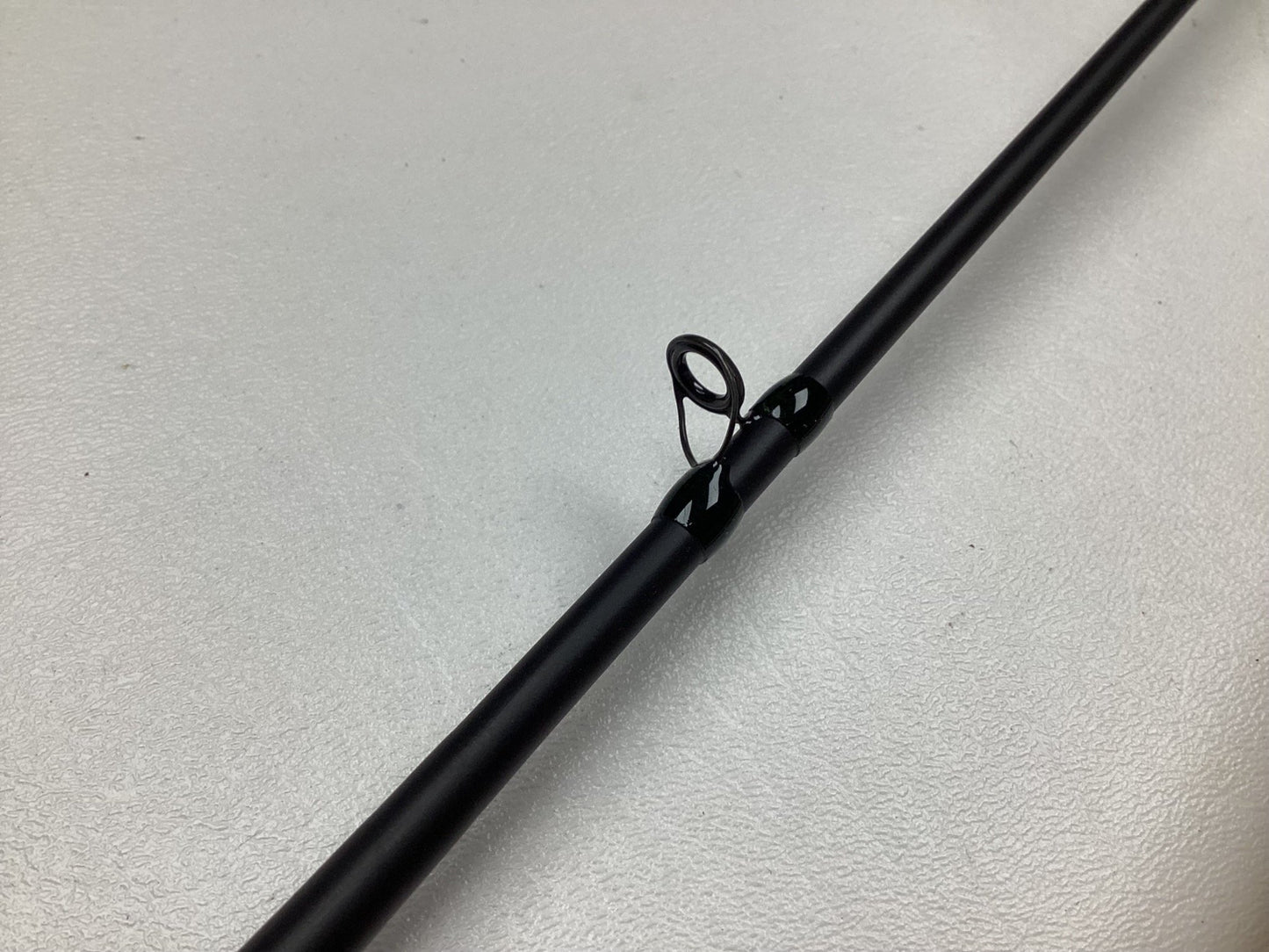 Close-up of a G. Loomis IMX-PRO Steelhead Casting Rod in mint condition on a light surface. The image highlights the glossy, circular line guide, ideal for those joining the Rod and Reel Trade-In Program to earn store credit.