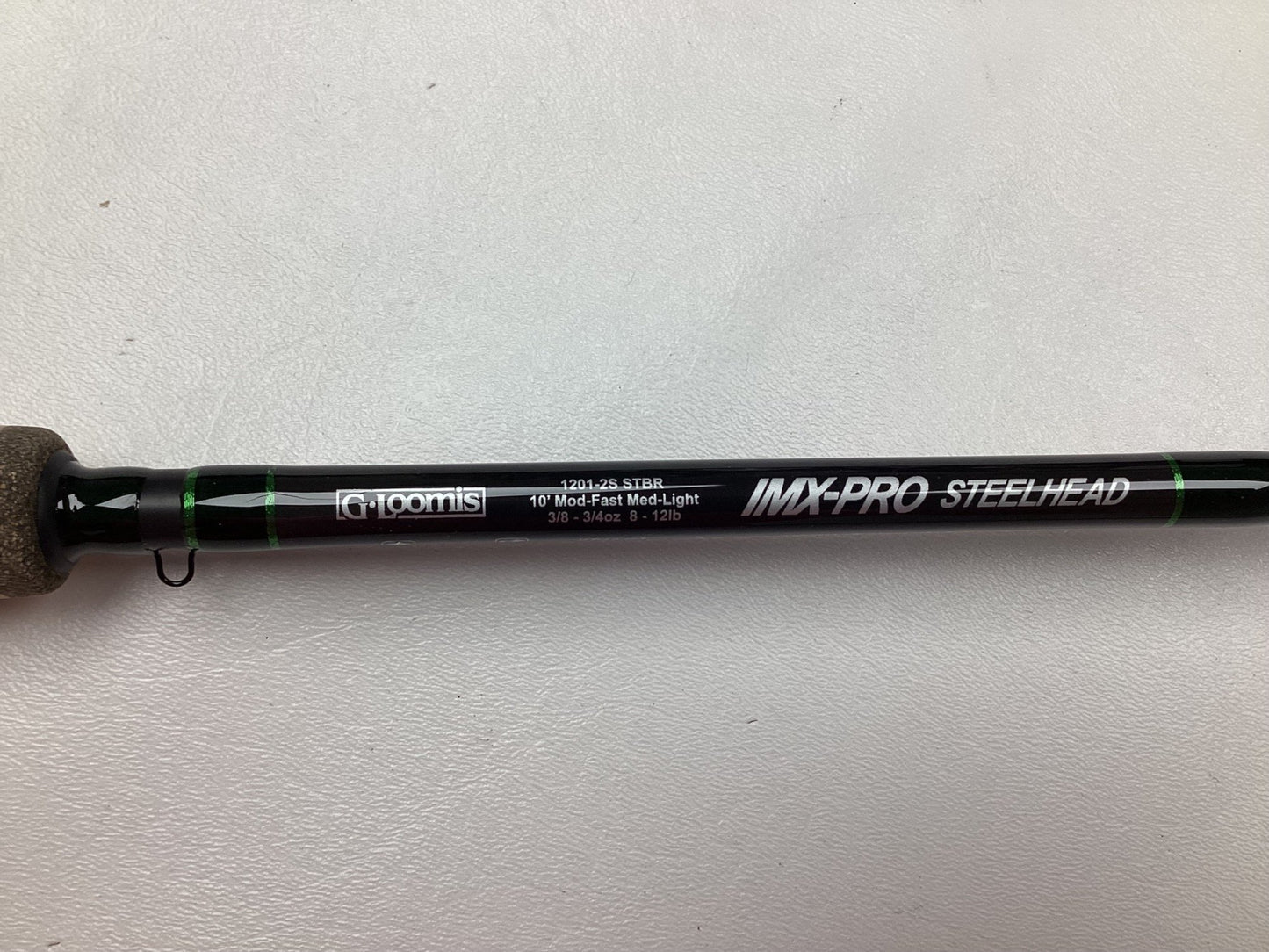 Close-up of a G. Loomis IMX-PRO Steelhead Bead rod, showing its 10' length and medium-light action suitable for 8-12 lb lines, with the handle visible on the left.