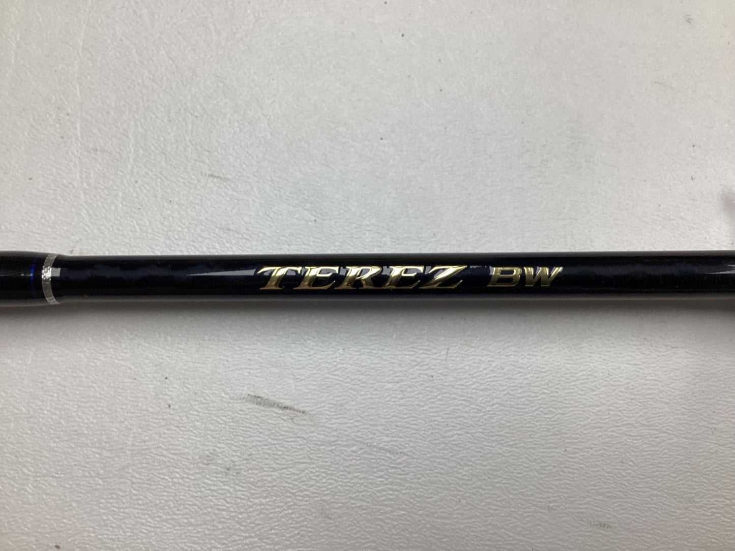 Close-up of a black Shimano Terez BW 6'6" Medium Heavy Rod with "TEREZ PW" in gold, set against white. Ideal for our Trade-In program or earning store credit by upgrading your gear.