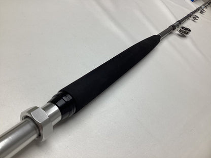 Close-up shot of a Shimano Terez BW Full Roller Uni Butt Rod lying on a white surface, featuring its black grip and metallic rings. Consider trading it in through our Rod and Reel Trade-In Program for valuable store credit.