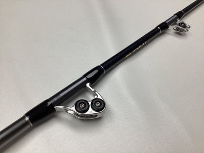 A Shimano Terez BW Full Roller Uni Butt Rod in mint used condition sits on a light gray surface. With its black and silver accents, shiny guide rings, and textured grip handle, it’s perfect for our Rod and Reel Trade-In Program.