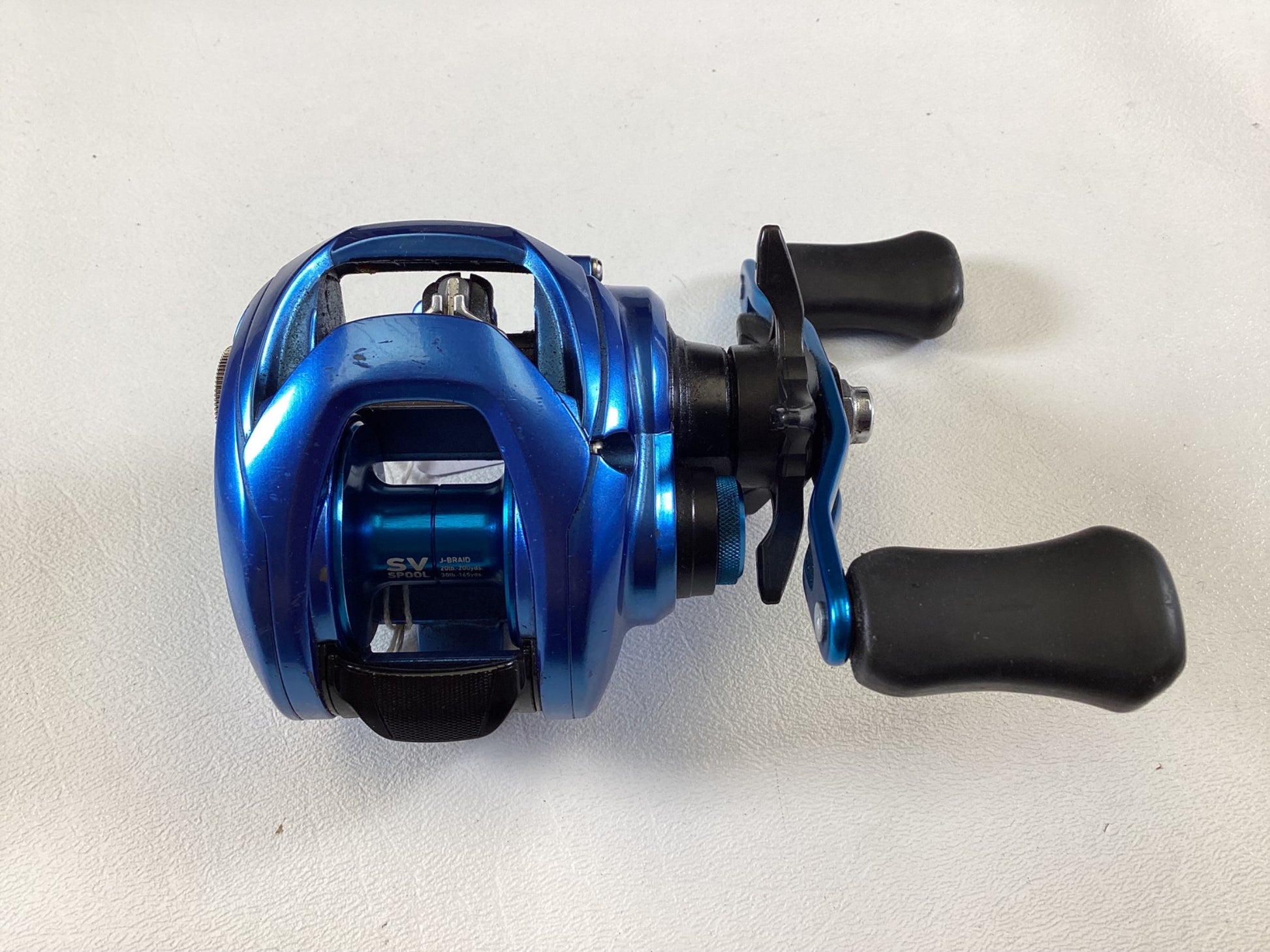 The Daiwa Coastal TWS CLSVTW150HS Used Casting Reel in blue, part of our Rod and Reel Trade-In collection, features two black handles set against a white background and is in very good condition.