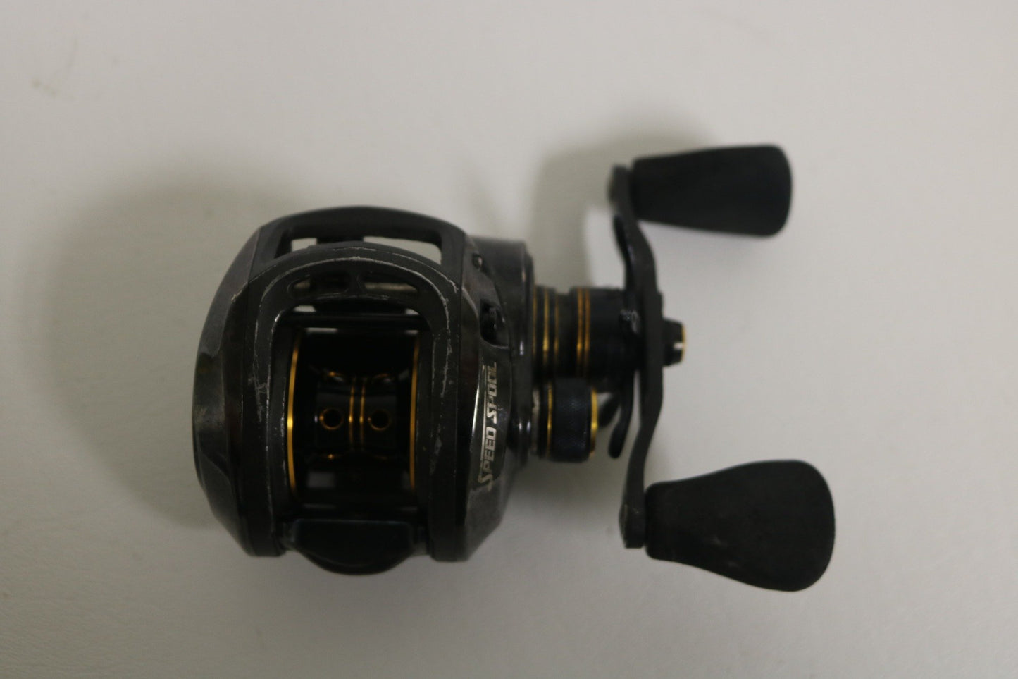 The Lew's Pro Speed Spool TLP1HZ 6.4:1 RH used casting reel in fair condition, featuring a black design with metallic accents and dual handles, is displayed on a plain white background. This sturdy Lew's reel could earn store credit in our Rod and Reel Trade-In program.