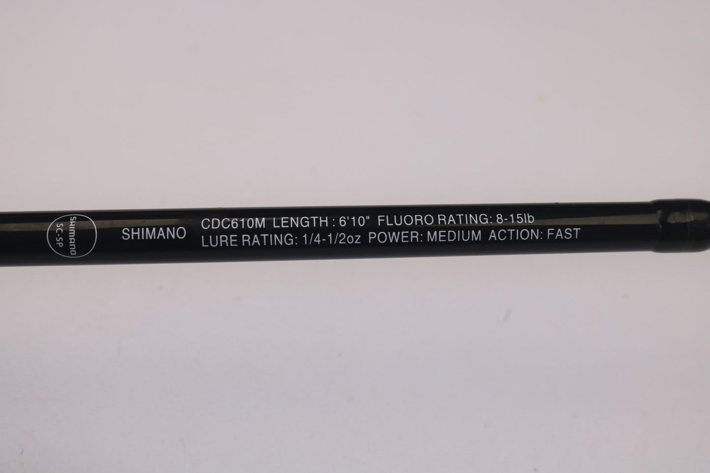 Get a close-up of the Shimano Curado CDC610M 6'10" Medium casting rod: Fluoro Rating of 8-15lb, Lure Rating of 1/4-1/2oz, Power Medium, Fast Action. Its sleek black design with white text could be your perfect catch—consider our Rod and Reel Trade-In Program to upgrade used gear.