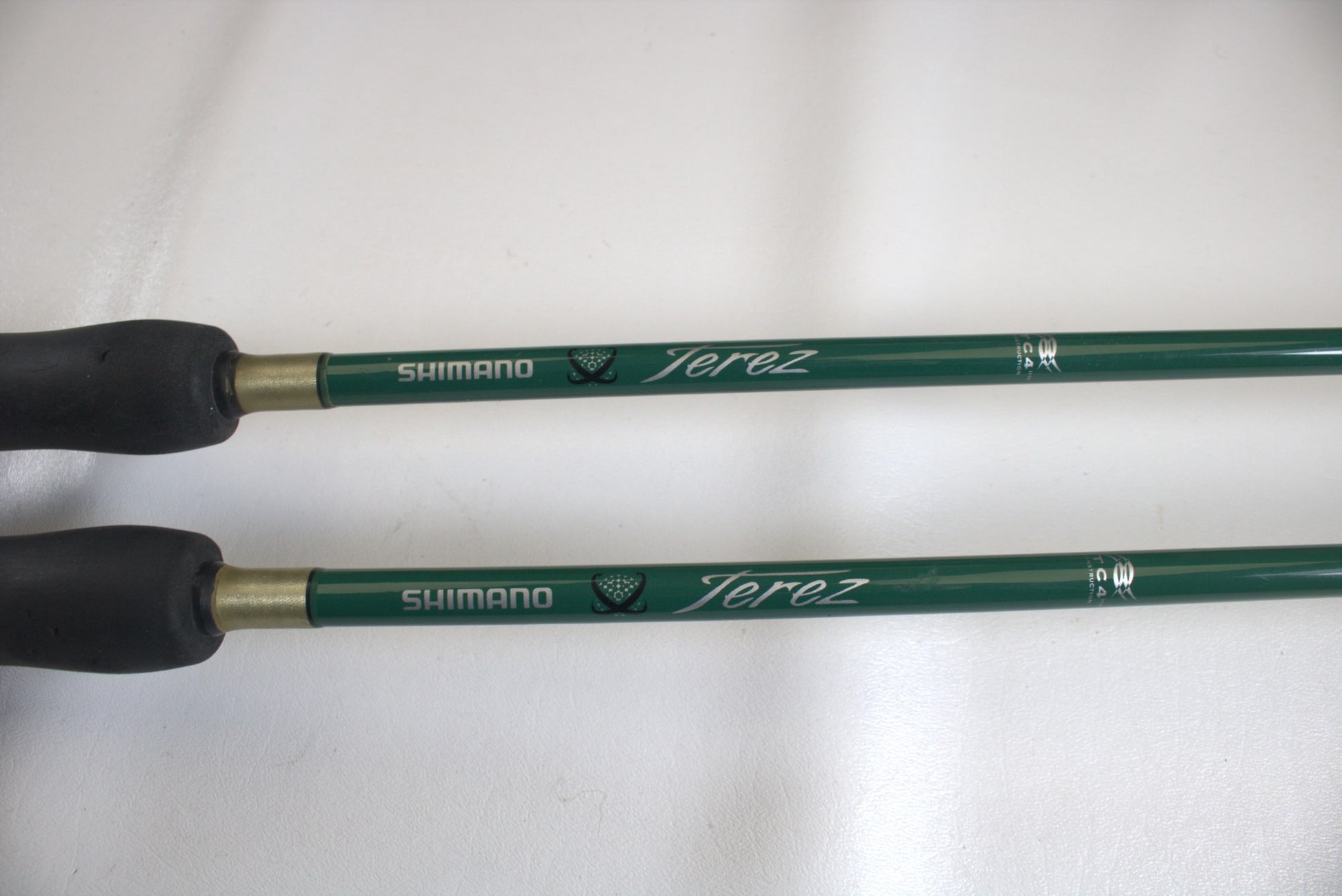 Two Shimano Terez Evergreen TZS-72MH 7'2" medium heavy spinning rods in good condition with black handles are shown on a white surface, featuring "Shimano" and "Terez" logos in white.