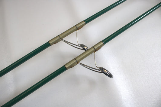 Close-up of two Shimano Terez Evergreen TZS-72MH 7'2" medium-heavy spinning rod tips with silver loops and gold connectors, positioned on a white surface.