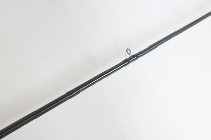 A close-up of the Shimano Poison Adrena PAD1610MGA 6'10" Medium Glass casting rod highlights its black, glossy shaft and single guide ring diagonally on a white background. Ideal for enthusiasts looking to upgrade gear through the trade-in program for store credit.