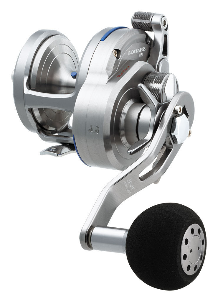 A metallic silver Daiwa Saltiga 6.4:1 Star Drag Left Hand Convention Reel SASD15HL features a black handle, Magsealed ball bearing technology, and intricately designed parts for heavy-duty saltwater fishing. The "Saltiga" brand is prominently displayed on its side.