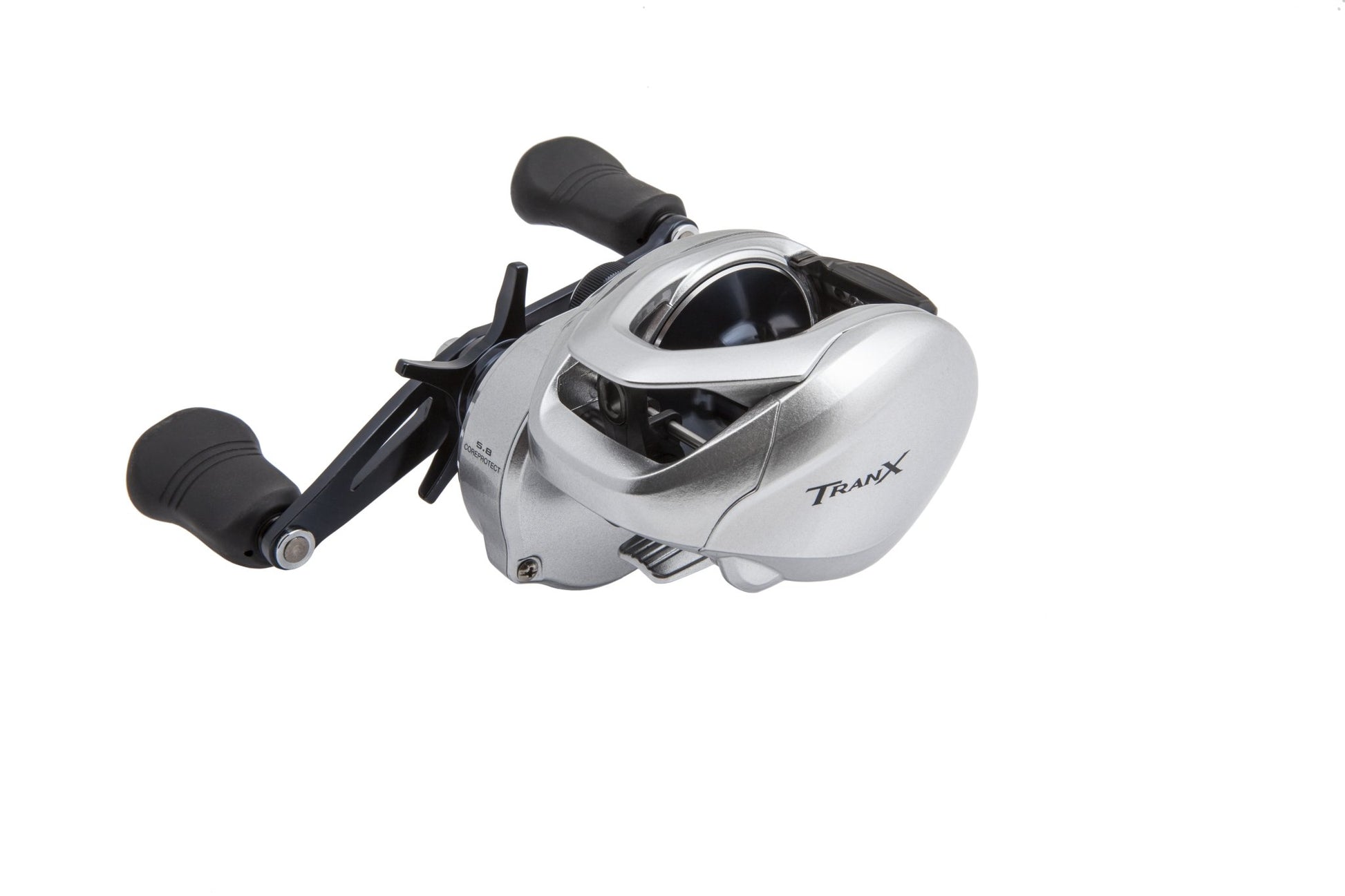 The Shimano Tranx 400 5.8:1 Casting Reel (TRX400A) by americanlegacyfishing showcases dual black handles and a sleek silver design. It features CoreProtect technology with "Tranx" boldly displayed on the side.