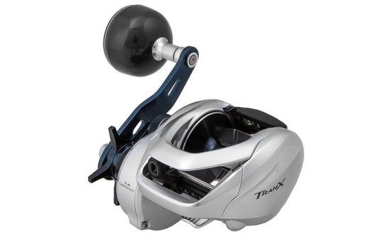 The Shimano Tranx 400HG 7.6:1 Casting Reel by americanlegacyfishing features a silver and black design with a large handle, "Tranx" branding, and CoreProtect technology for durability—ideal for versatile fishing activities.